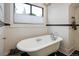 Bright bathroom showcasing a luxurious white clawfoot bathtub beneath a window at 3943 Newton St, Denver, CO 80211