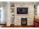 Elegant living room featuring a stone fireplace, built-in shelving, and hardwood floors at 3943 Newton St, Denver, CO 80211