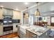 Stylish kitchen island with granite countertop, stainless steel appliances, and pendant lighting at 3943 Newton St, Denver, CO 80211