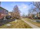 View of grassy community green space and walking path with mature trees at 9285 W 87Th Pl, Arvada, CO 80005