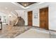 Elegant foyer featuring a curved staircase, stone flooring, and decorative lighting at 325 Clayton St, Denver, CO 80206