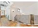 Bright hallway showcasing wooden floors, a skylight, and decorative wall sconces at 325 Clayton St, Denver, CO 80206