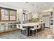Spacious kitchen featuring a large island with seating, stainless steel appliances, and stone tile flooring at 325 Clayton St, Denver, CO 80206