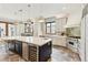 Bright kitchen featuring a large island with seating, stainless steel appliances, and stone tile flooring at 325 Clayton St, Denver, CO 80206