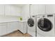 Well-equipped laundry room with modern washer, dryer, sink, and plenty of cabinet space at 325 Clayton St, Denver, CO 80206