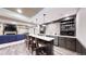 Finished basement with a stone accent wet bar, barstool seating, fireplace and blue sofa at 3891 W 149Th Ave, Broomfield, CO 80023