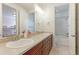 Bright bathroom featuring double vanity, white countertops, cherry wood cabinets, and tiled shower and bath at 3891 W 149Th Ave, Broomfield, CO 80023