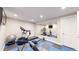Home gym with exercise equipment, blue and black mat flooring, and a mirrored wall at 3891 W 149Th Ave, Broomfield, CO 80023