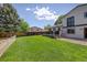 Backyard offering a spacious lawn, mature trees, and a deck, creating a wonderful space for outdoor activities at 13695 W 67Th Cir, Arvada, CO 80004