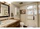 Bathroom with brown marble countertop vanity, adjacent to a laundry room or other living space at 13695 W 67Th Cir, Arvada, CO 80004