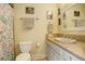 Well-maintained bathroom with a single vanity, toilet, and shower featuring a floral shower curtain at 13695 W 67Th Cir, Arvada, CO 80004