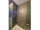 Shower stall with dark tile surround, and glass doors in a remodeled bathroom at 13695 W 67Th Cir, Arvada, CO 80004