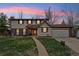 Charming two-story home boasts a well-manicured lawn, mature trees, and a welcoming entrance at 2410 S Lima St, Aurora, CO 80014