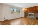 Cozy living room with wood floors, a brick fireplace, and a bright window at 2410 S Lima St, Aurora, CO 80014