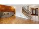 Bright living room featuring a brick fireplace, wood paneling, and elegant wood floors at 2410 S Lima St, Aurora, CO 80014