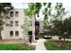 Apartment building exterior with brick facade, black windows and trees on a landscaped lot at 636 N Washington St # 301, Denver, CO 80203