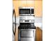 Bright kitchen featuring stainless steel microwave and oven with light wood cabinets at 636 N Washington St # 301, Denver, CO 80203
