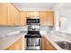 Close-up of kitchen area featuring stainless steel oven, stovetop, microwave, and light wood cabinets at 636 N Washington St # 301, Denver, CO 80203