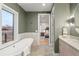 Elegant bathroom with a soaking tub, double vanity, and natural light at 2056 S Ogden St, Denver, CO 80210
