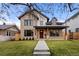 Beautiful two-story home with a brick facade, covered porch, and manicured lawn at 2056 S Ogden St, Denver, CO 80210