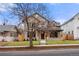 Charming home exterior with stone and siding accents, lush lawn, and a welcoming front porch at 2056 S Ogden St, Denver, CO 80210