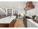 Spacious kitchen featuring a large island, custom range hood, and modern appliances at 2056 S Ogden St, Denver, CO 80210