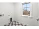 This bright laundry room offers modern washer and dryer connections and checkerboard flooring at 2056 S Ogden St, Denver, CO 80210