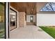 A covered patio with a folding glass wall allows view into the dining area and features a wood ceiling and brick columns at 2056 S Ogden St, Denver, CO 80210
