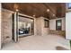 Covered patio featuring wood ceiling and brick columns with folding glass door into living room at 2056 S Ogden St, Denver, CO 80210