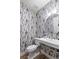 Chic powder room with striking woodland wallpaper, stylish fixtures and a floating sink at 2056 S Ogden St, Denver, CO 80210