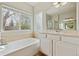 Bathroom featuring a tub and shower, large window, a sink and vanity, and linoleum floors at 14938 Clayton St, Thornton, CO 80602