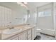 Bathroom includes double sinks with large mirror and tub/shower combination with tile surround at 14938 Clayton St, Thornton, CO 80602
