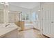 Well-lit bathroom with tiled shower, soaking tub, and vanity with sink and generous countertop space at 14938 Clayton St, Thornton, CO 80602