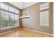 Bright dining room featuring hardwood floors, a modern chandelier, and large windows with scenic views at 14938 Clayton St, Thornton, CO 80602