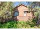 Charming brick house featuring unique arched window and lush landscaping at 1257 Quitman St, Denver, CO 80204