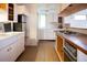 Bright kitchen with white cabinets, tile flooring, and a built-in stovetop on the island at 1257 Quitman St, Denver, CO 80204