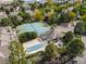 Aerial view showcasing tennis courts, pool, and community buildings surrounded by lush trees at 5745 W Atlantic Pl # 108, Lakewood, CO 80227