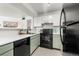 Clean kitchen with white counters, black appliances, and mint green cabinets at 5745 W Atlantic Pl # 108, Lakewood, CO 80227