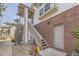 Exterior view of townhome, showcasing the brick facade, staircase, and convenient side entrance at 3010 W Prentice Ave # J, Littleton, CO 80123