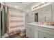 Well-lit bathroom with a shower with a pink curtain, and a white vanity at 12112 Melody Dr # 302, Denver, CO 80234