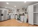 Bright kitchen with stainless steel appliances, white cabinetry, and stylish open shelving for storage at 12112 Melody Dr # 302, Denver, CO 80234