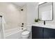 Clean bathroom featuring a tub and shower combo, modern vanity, and a black framed mirror at 1250 Yates St, Denver, CO 80204