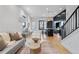 Bright living room featuring hardwood floors, a stylish gray sofa, and a modern staircase at 1250 Yates St, Denver, CO 80204