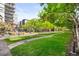 Expansive green lawn with a winding stone pathway and mature shade trees at 1401 Delgany St # 211, Denver, CO 80202