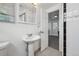 Classic white bathroom with a pedestal sink, view to room with sitting area and exterior door at 925 Fulton St, Aurora, CO 80010