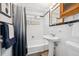 Retro style bathroom featuring white tile, a pedestal sink, and a bathtub with shower at 925 Fulton St, Aurora, CO 80010