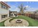 Large backyard with artificial turf, a stone fire pit, playset, covered patio, and fenced perimeter at 12079 E Louisiana Ave, Aurora, CO 80012