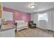 Bedroom featuring a crib, changing table, soft carpet, and a decorative accent wall at 12079 E Louisiana Ave, Aurora, CO 80012