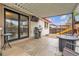 Covered patio with stone pavers, stainless steel grill, television, and outdoor seating, perfect for entertaining at 12079 E Louisiana Ave, Aurora, CO 80012