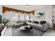 Staged living room features a modern sofa, stylish decor, and ample natural light from large windows at 9451 E Evans Pl, Denver, CO 80231